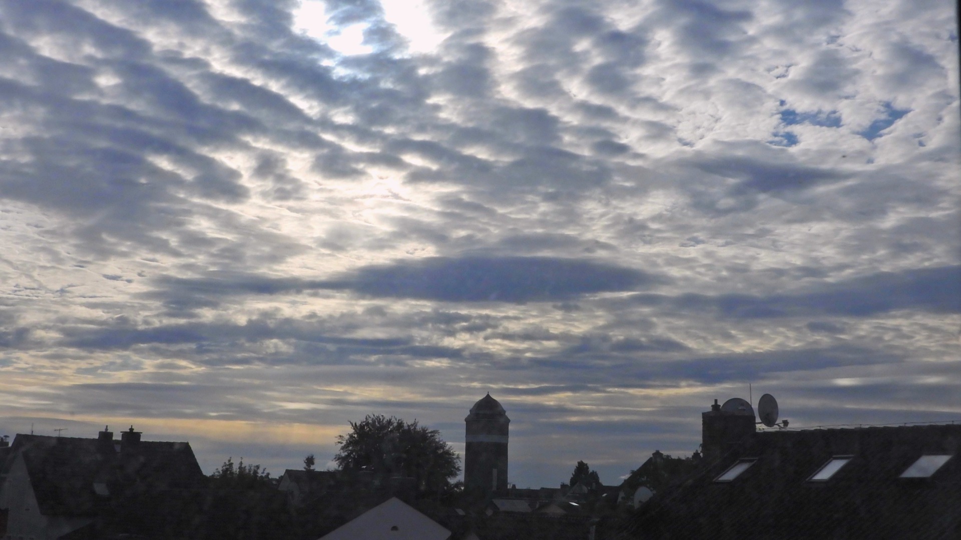 Eine stark gegliederte Wolkendecke über dem Wasserturm